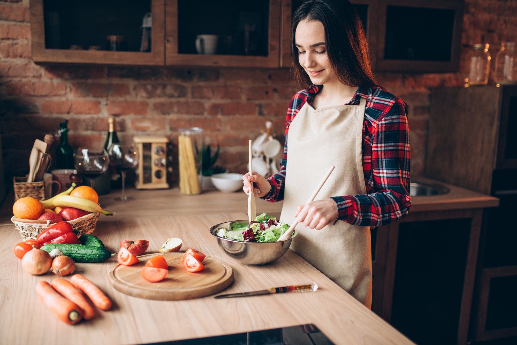 Female cook, salad cooking on the kitchen