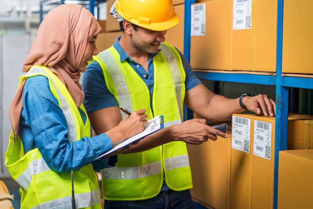 Asian Idian worker man with Muslim worker woman working together by scanning bar code