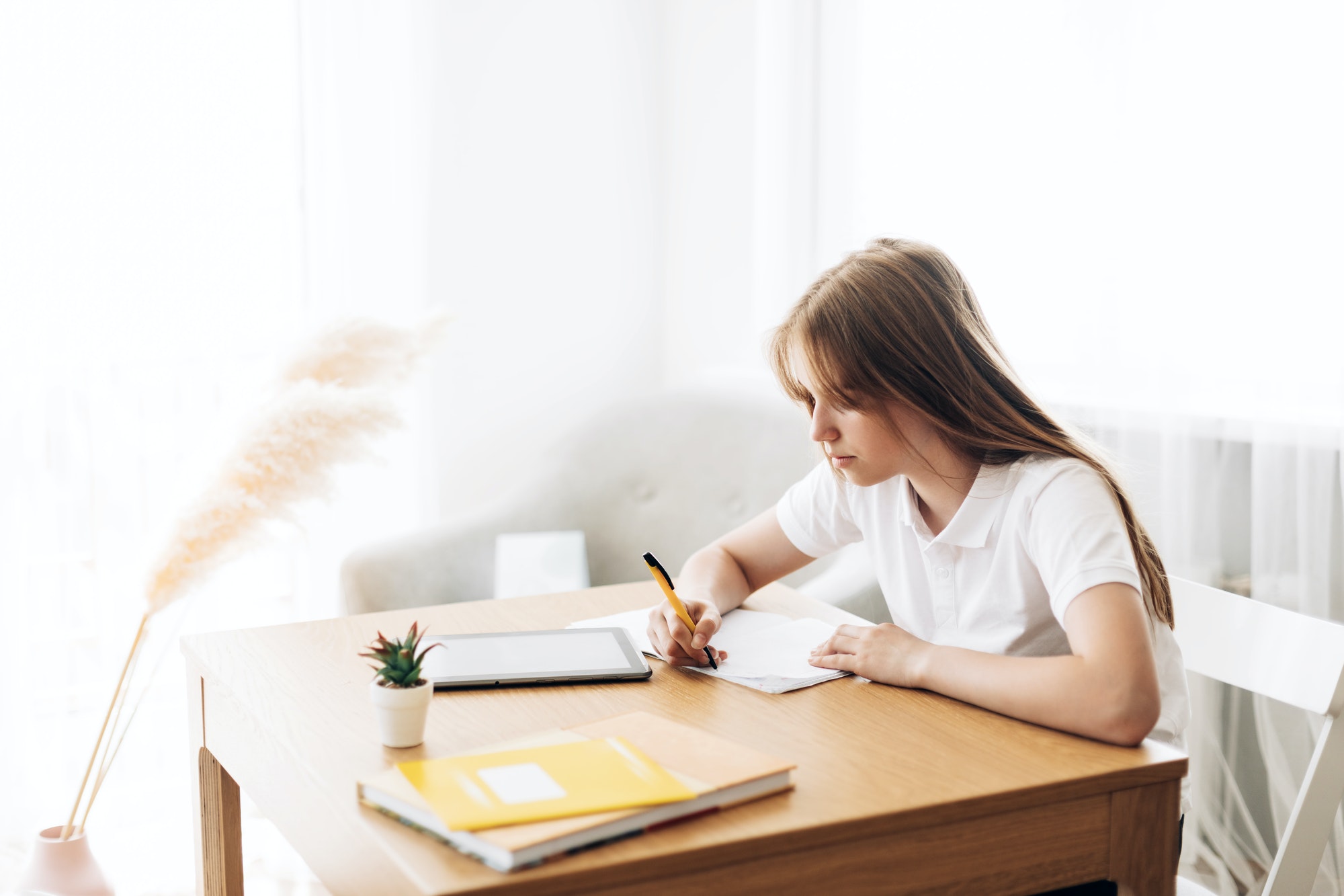 A teenage girl does her homework alone. The concept of education and upbringing, homework