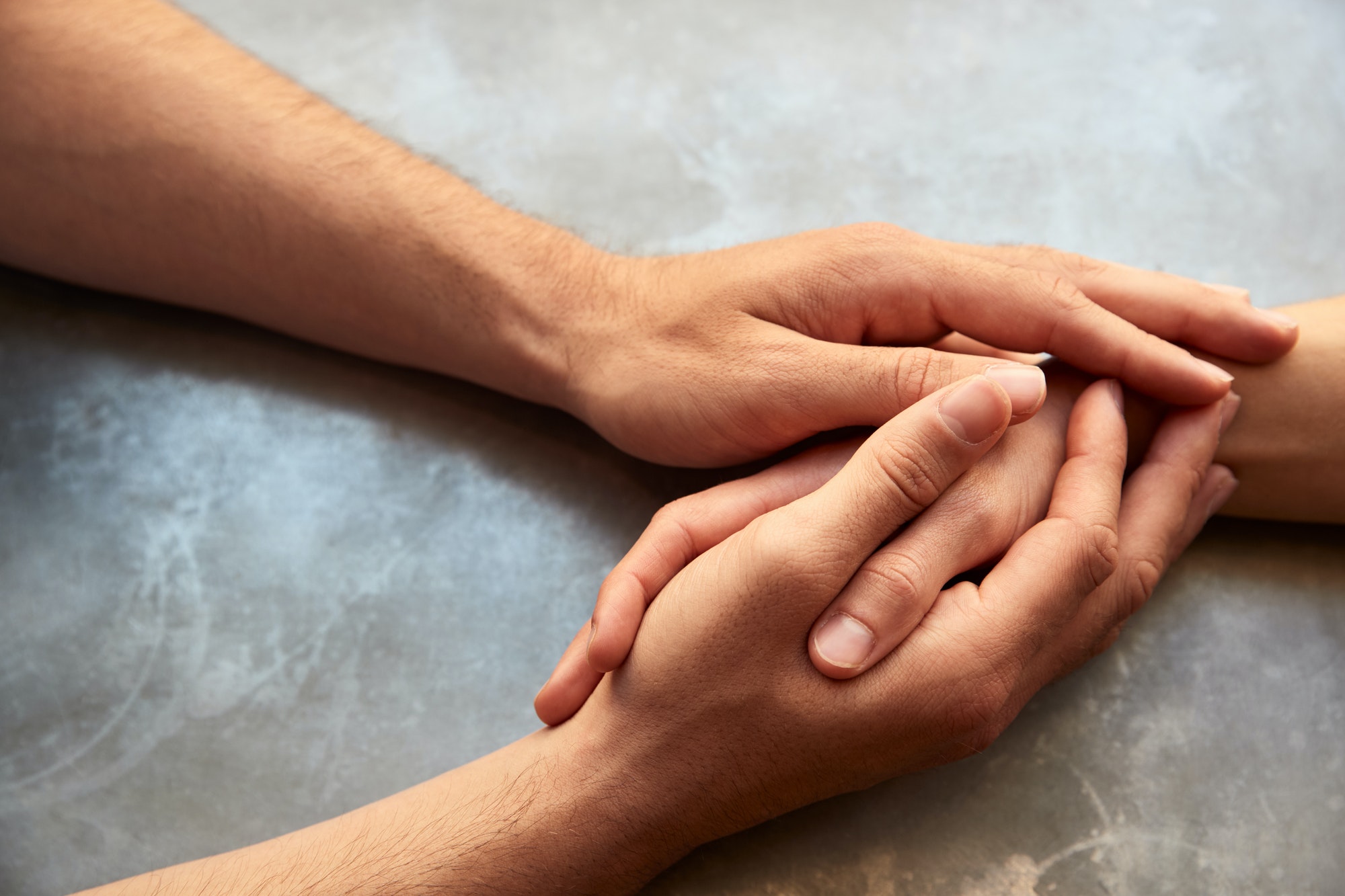 Close Up Of Loving Male Gay Couple Sitting At Table In Coffee Shop Holding Hands